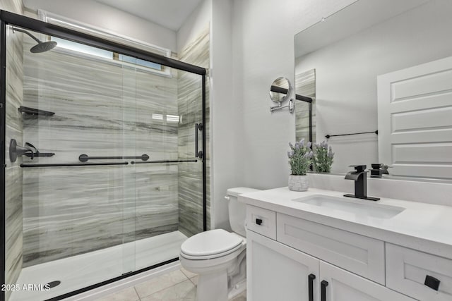 bathroom featuring tile patterned flooring, vanity, toilet, and walk in shower