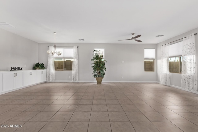 unfurnished room featuring ceiling fan with notable chandelier and light tile patterned floors