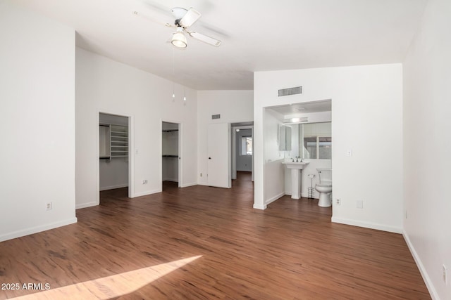 unfurnished living room with ceiling fan, dark hardwood / wood-style flooring, and vaulted ceiling