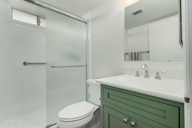 bathroom with toilet, a shower with shower door, and vanity