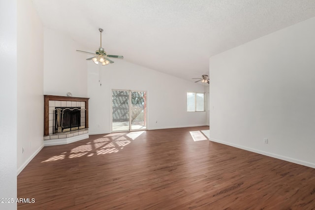 unfurnished living room featuring vaulted ceiling, a textured ceiling, a fireplace, dark hardwood / wood-style flooring, and ceiling fan