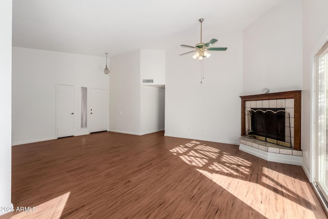 unfurnished living room featuring ceiling fan, dark wood-type flooring, and a fireplace