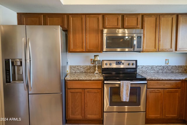 kitchen with light stone countertops and stainless steel appliances