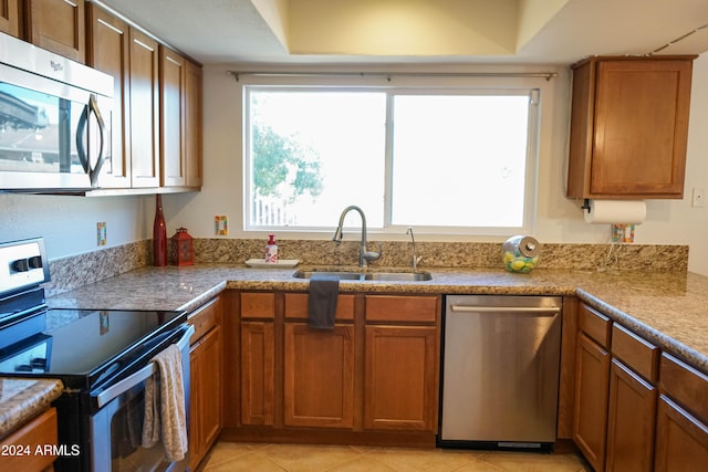 kitchen with appliances with stainless steel finishes, light tile patterned floors, and sink