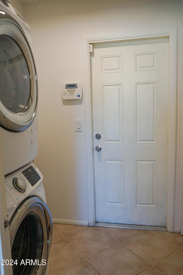 laundry room with light tile patterned floors and stacked washer and clothes dryer