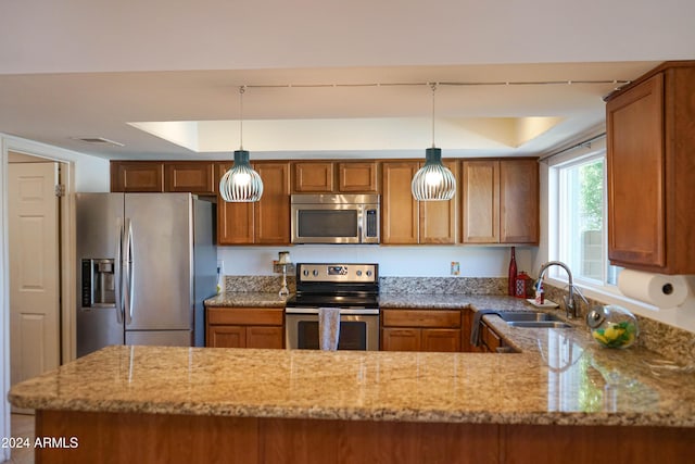 kitchen featuring a raised ceiling, sink, light stone countertops, decorative light fixtures, and stainless steel appliances