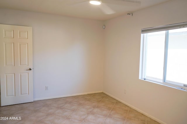 tiled spare room featuring ceiling fan