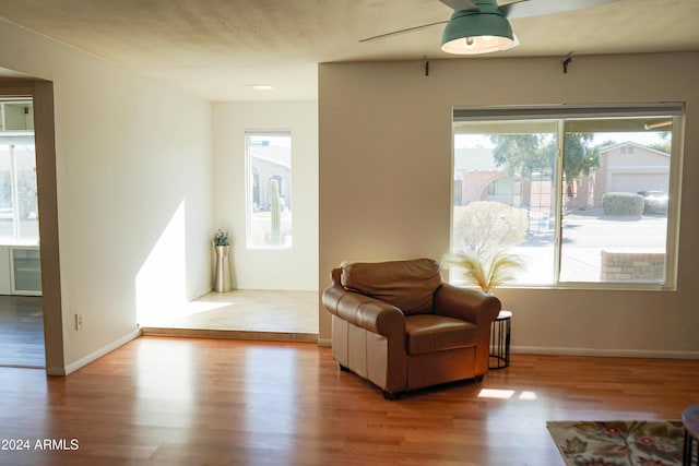 sitting room with ceiling fan and light hardwood / wood-style flooring