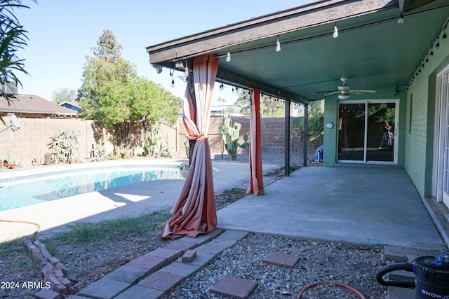 exterior space featuring a fenced in pool and ceiling fan