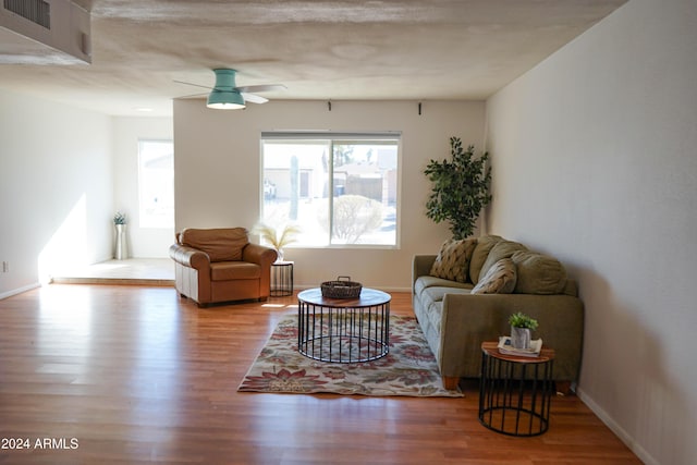 living room with ceiling fan, wood-type flooring, and a textured ceiling