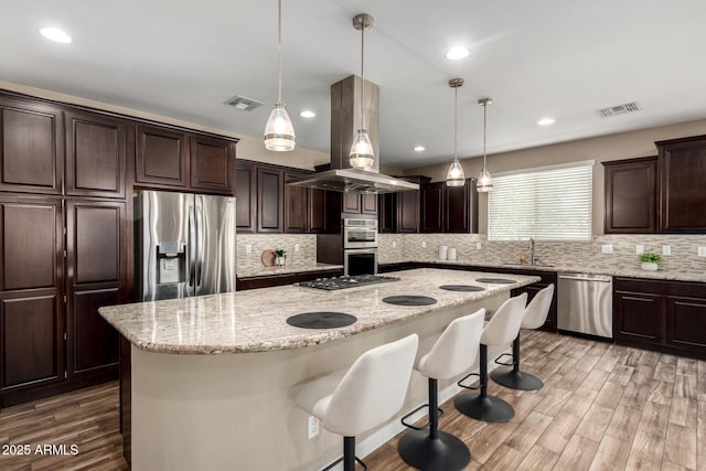 3338 E Coconino Dr, Gilbert, AZ 85298 - kitchen with stainless steel appliances, island exhaust hood, dark brown cabinets, backsplash, and recessed lighting