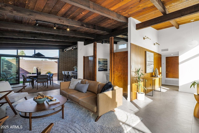 living room with beamed ceiling, wood ceiling, a high ceiling, and track lighting