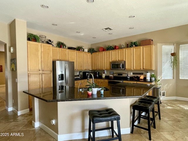 kitchen with sink, stainless steel appliances, a breakfast bar, and a spacious island