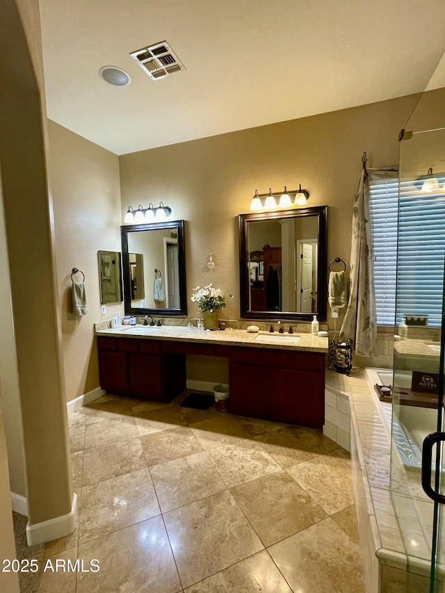 bathroom featuring vanity and tiled bath