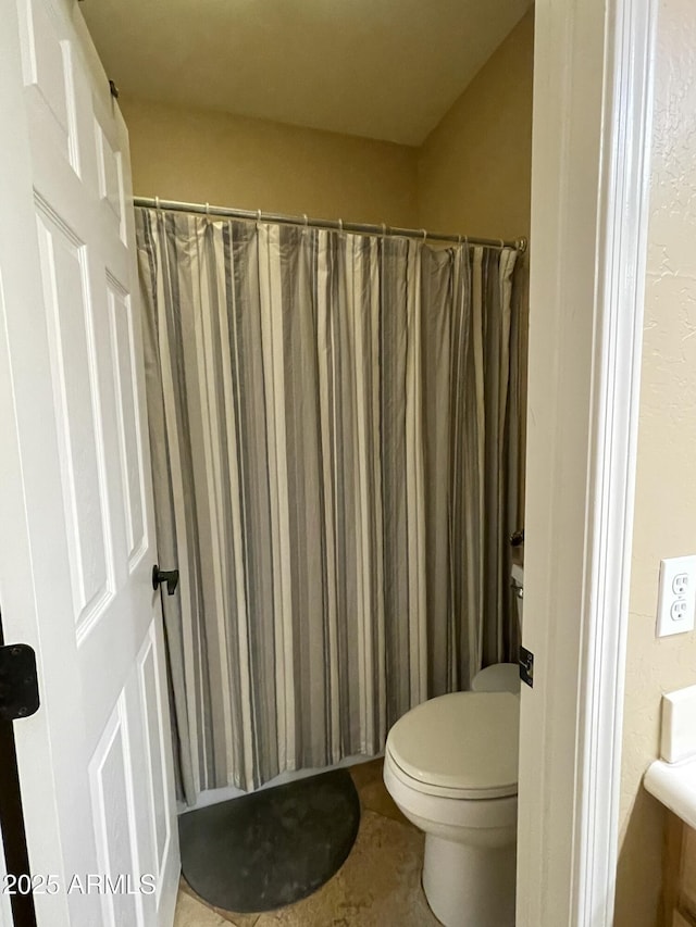 bathroom with toilet and curtained shower