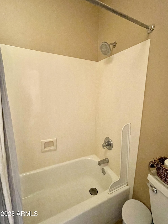 bathroom featuring shower / washtub combination and toilet