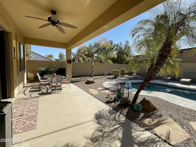 view of patio / terrace featuring ceiling fan and a fenced in pool