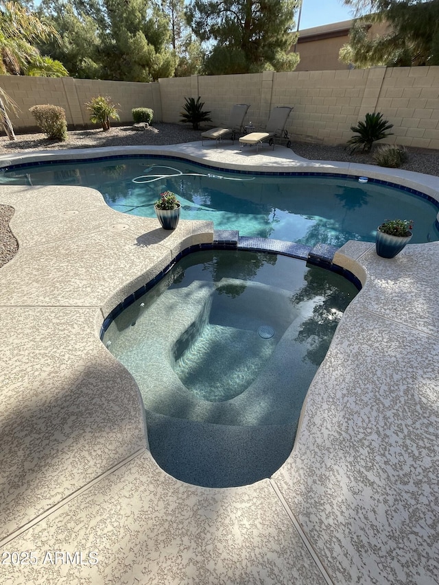 view of pool with an in ground hot tub