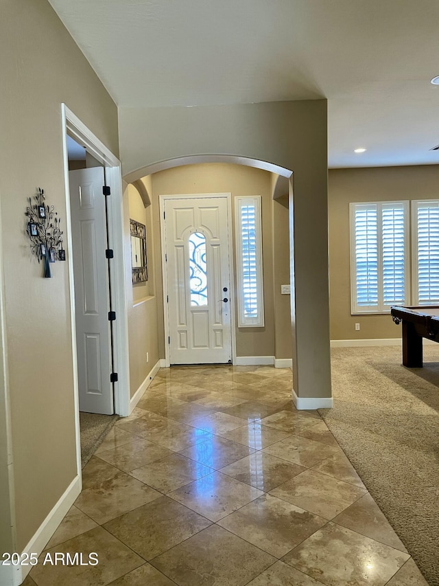 entryway featuring plenty of natural light and carpet flooring