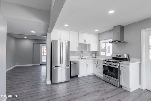 6316 N 23rd Ave, Phoenix, AZ 85015 - kitchen with stainless steel appliances, wall chimney exhaust hood, a sink, white cabinetry, and light countertops