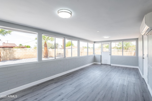 6316 N 23rd Ave, Phoenix, AZ 85015 - unfurnished sunroom featuring brick wall, baseboards, wood finished floors, and a wall mounted AC