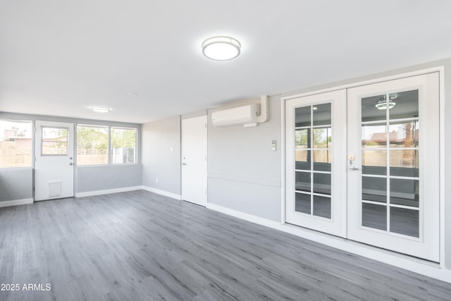 6316 N 23rd Ave, Phoenix, AZ 85015 - empty room featuring a wall unit AC, wood finished floors, french doors, and baseboards