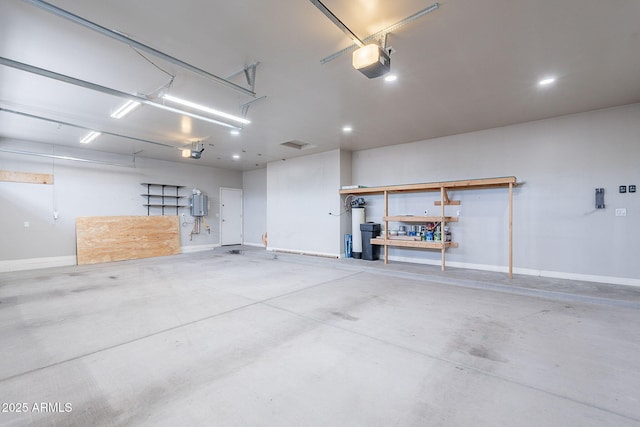 809 W Coles Rd, Phoenix, AZ 85041 - garage featuring a garage door opener, baseboards, water heater, and a workshop area