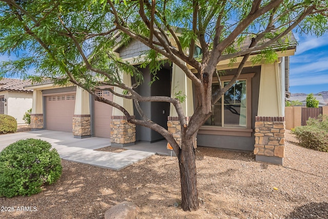 809 W Coles Rd, Phoenix, AZ 85041 - view of front of house featuring stone siding, driveway, stucco siding, and a garage