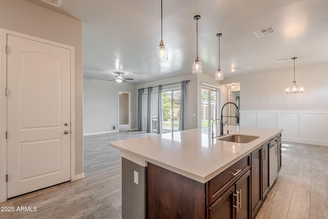 809 W Coles Rd, Phoenix, AZ 85041 - kitchen featuring a sink, light wood finished floors, dark brown cabinets, a ceiling fan, and hanging light fixtures