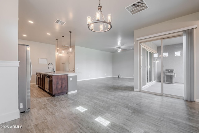 809 W Coles Rd, Phoenix, AZ 85041 - kitchen featuring stainless steel appliances, a sink, dark brown cabinets, light countertops, and light wood-type flooring