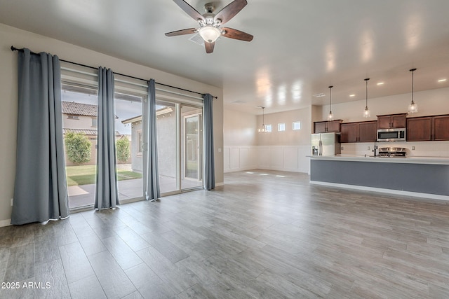 809 W Coles Rd, Phoenix, AZ 85041 - unfurnished living room with a ceiling fan, recessed lighting, a wainscoted wall, light wood finished floors, and a decorative wall