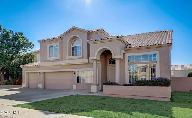 mediterranean / spanish-style home featuring a garage and a front yard