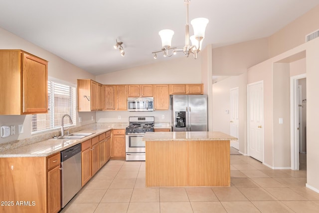 kitchen featuring light tile patterned floors, appliances with stainless steel finishes, vaulted ceiling, a sink, and a kitchen island