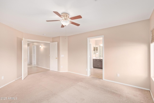 unfurnished bedroom with light colored carpet, ceiling fan, ensuite bath, and baseboards