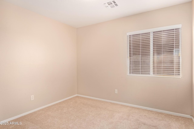 carpeted empty room featuring visible vents and baseboards