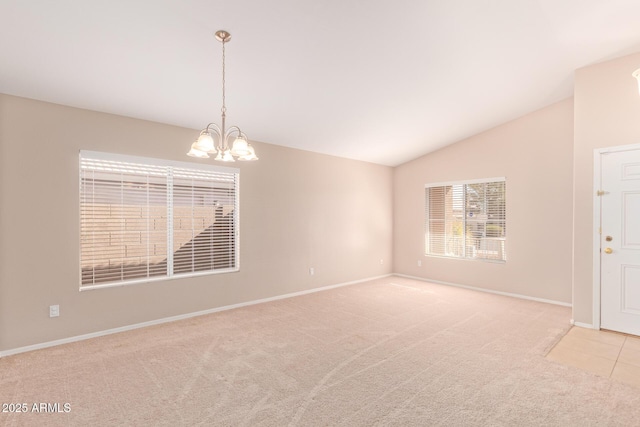 empty room with light carpet, vaulted ceiling, baseboards, and an inviting chandelier