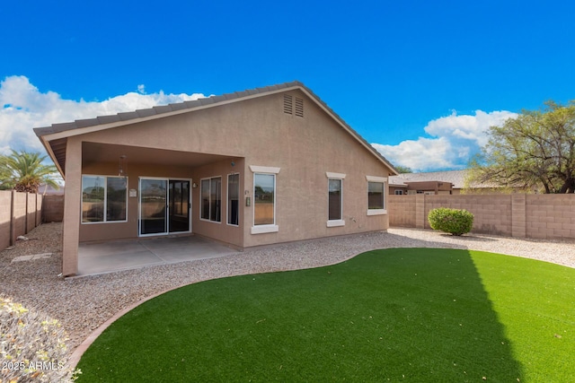 rear view of house featuring a patio area, a fenced backyard, a lawn, and stucco siding