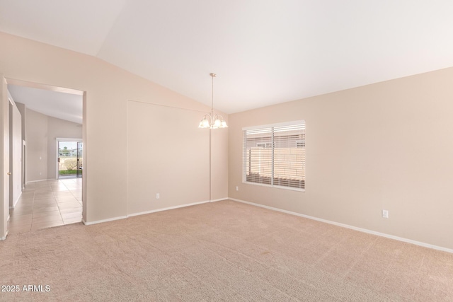 spare room featuring a notable chandelier, light tile patterned floors, lofted ceiling, light colored carpet, and baseboards