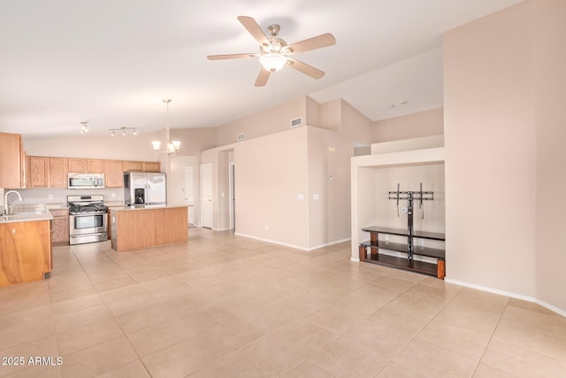 kitchen with lofted ceiling, stainless steel appliances, a kitchen island, a sink, and light countertops