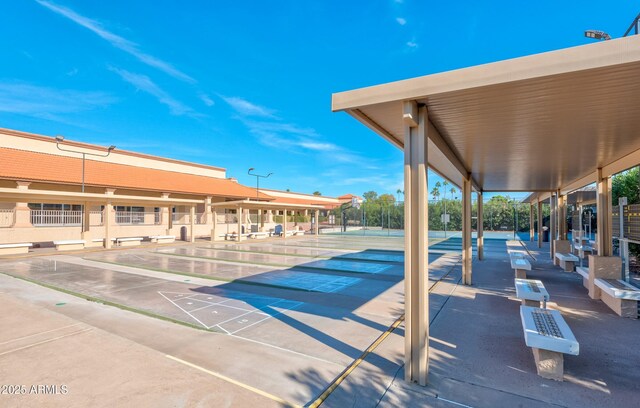 view of property's community featuring shuffleboard and fence