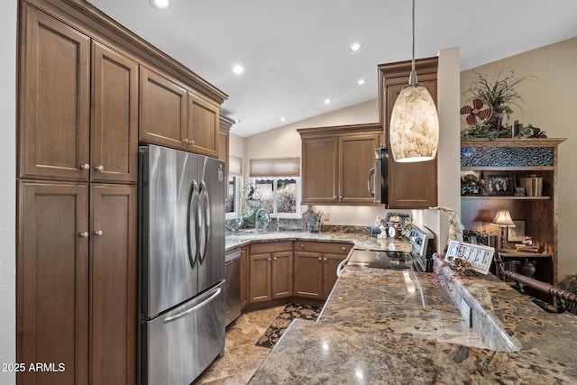 kitchen featuring lofted ceiling, stainless steel appliances, a peninsula, hanging light fixtures, and dark stone counters