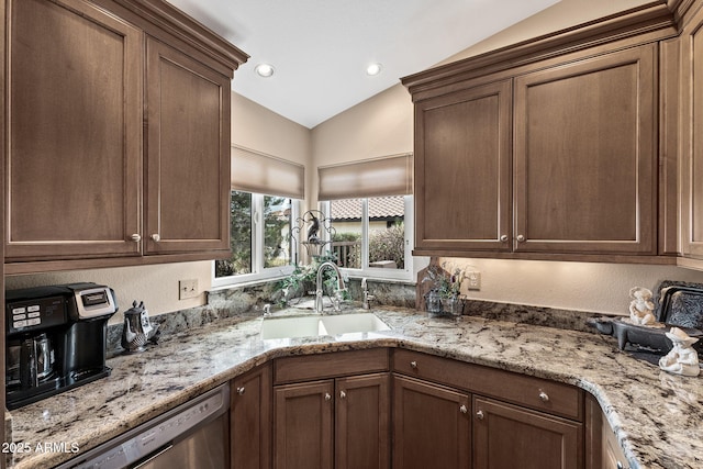 kitchen featuring lofted ceiling, recessed lighting, stainless steel dishwasher, a sink, and light stone countertops