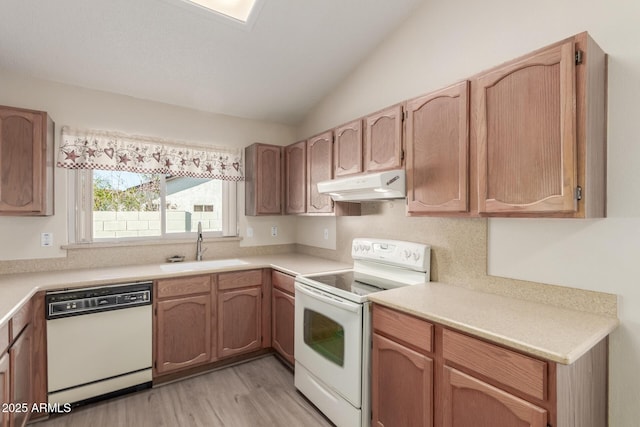 kitchen with sink, white appliances, light hardwood / wood-style flooring, and lofted ceiling