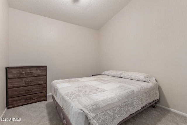 bedroom featuring light carpet, a textured ceiling, and lofted ceiling