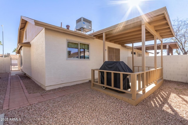 back of property with central AC unit and a wooden deck