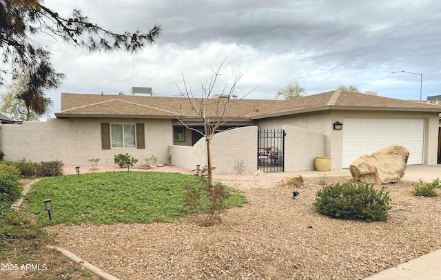 ranch-style house featuring an attached garage, driveway, a gate, and stucco siding