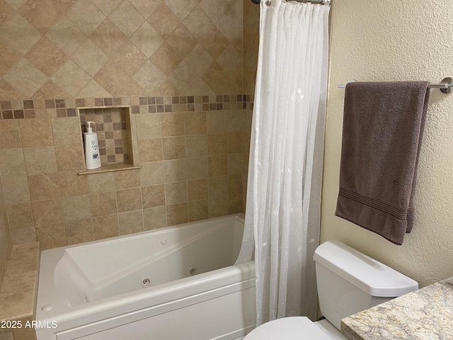 bathroom featuring toilet, a textured wall, vanity, and a combined bath / shower with jetted tub