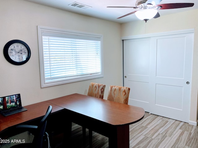 dining room with light wood-type flooring, visible vents, and a ceiling fan