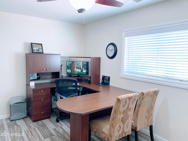 office space featuring a ceiling fan, visible vents, light wood-style floors, and baseboards