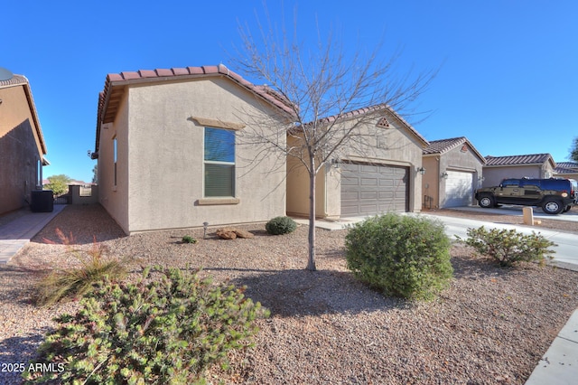 view of front of property featuring a garage and central AC